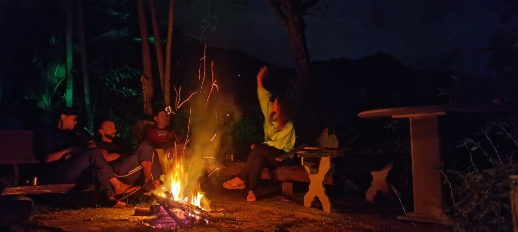 Noite de fogueira com amigos e faíscas sob o céu estrelado do Sana View