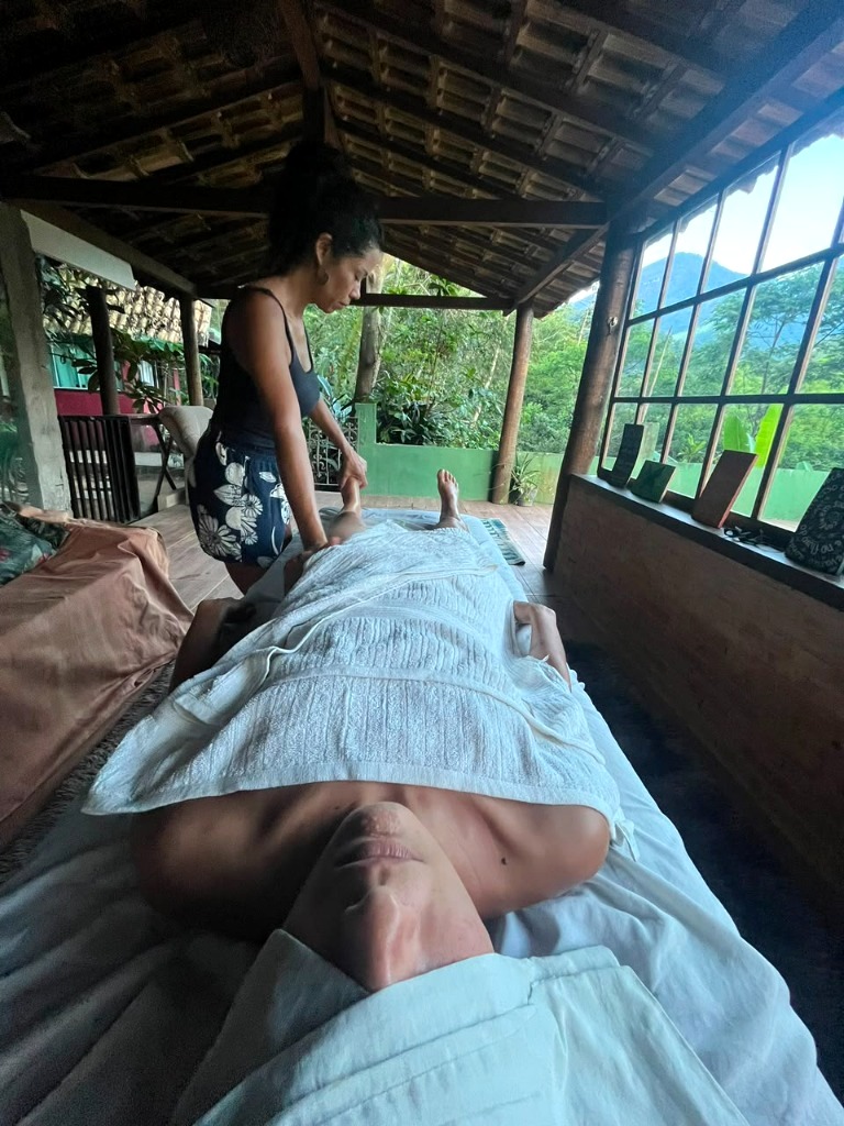 Sessão de massagem e relaxamento no chalé aberto com vista para as montanhas e floresta do Sana